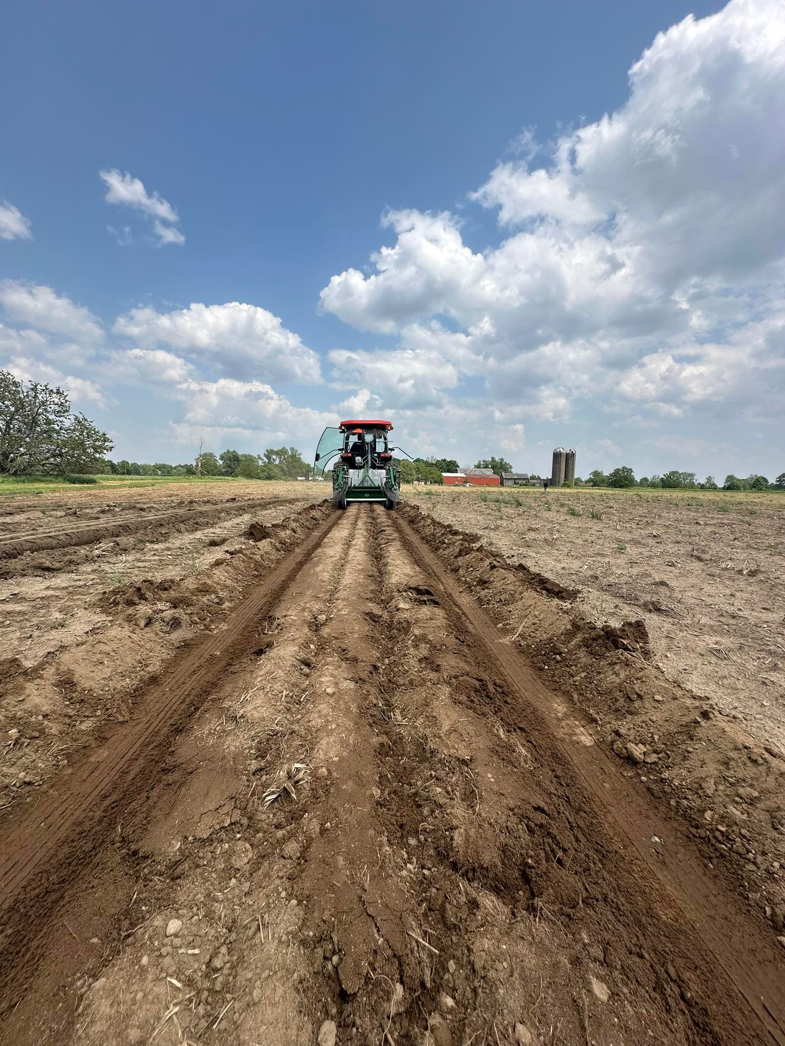 Tractor plowing fields toward the barn at Lifestyle Family Farms